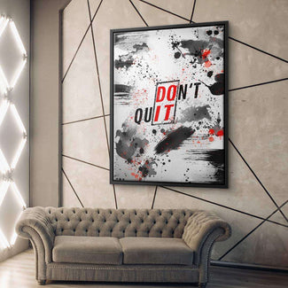 Modernes Wandbild mit „DON'T QUIT“-Schriftzug, abstrakte schwarze und rote Farbspritzer, stilvolles Wohnzimmer.