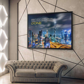 Modernes Wohnzimmer mit grauem Sofa und Leinwand-Wandbild Skyline mit Motivationsspruch