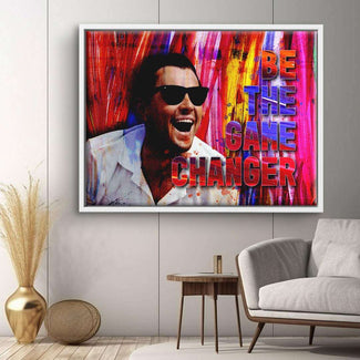 Modernes Wandbild mit lachendem Mann in Sonnenbrille und Schriftzug 'Be the Game Changer' vor buntem Hintergrund, Wohnzimmer-Dekor, Motivationskunst auf Leinwand.