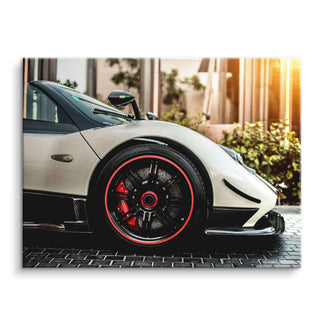 Modernes Wandbild mit weißem Supersportwagen, Fokus auf Vorderrad, Sonnenlicht, urbane Kulisse