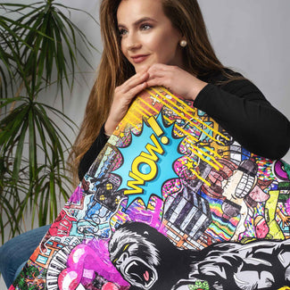 Frau hält buntes Pop Art Wandbild mit Gorilla-Motiv und Wow-Schriftzug vor neutralem Hintergrund