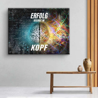 Motivationsbild mit buntem Gehirn, Formeln und Spruch 'Erfolg beginnt im Kopf' an Wand.