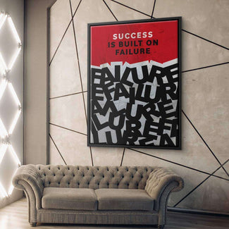 Modernes Wandbild mit Motivationsspruch 'Success is built on failure' über grauem Sofa