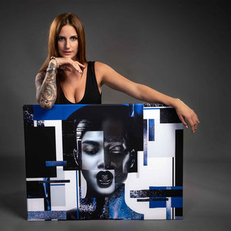 Frau mit tätowiertem Arm präsentiert modernes Wandbild Frauenkopf mit abstrakten blauen Elementen